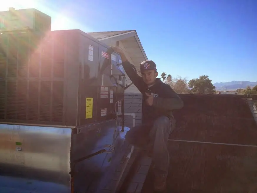HVAC technician performing Heat Pump Repair on a rooftop unit in Pomona